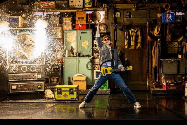 Ben Joyce posing as Marty McFly with his guitar on stage in Back to the Future The Musical