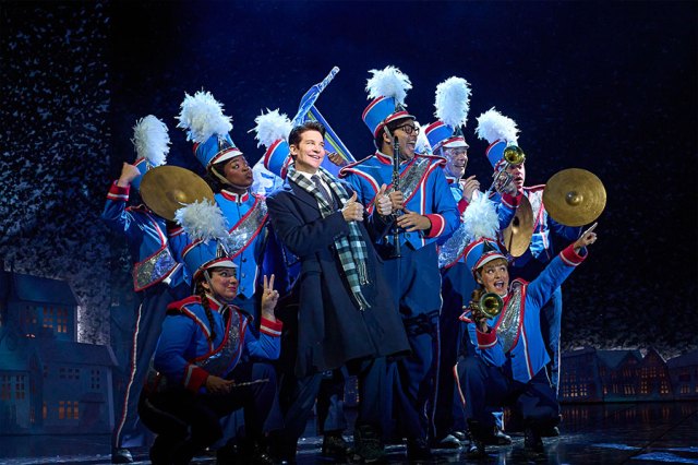 The cast of Groundhog Day pose on stage in band outfits