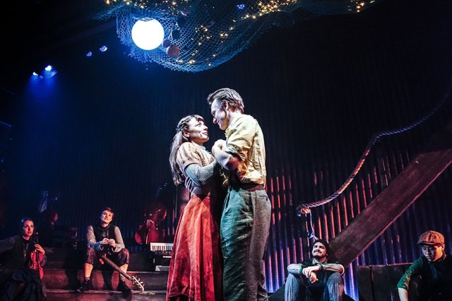 Molly Osborne and Jamie Parker in The Curious Case of Benjamin Button, dancing on stage and surrounded by ensemble members