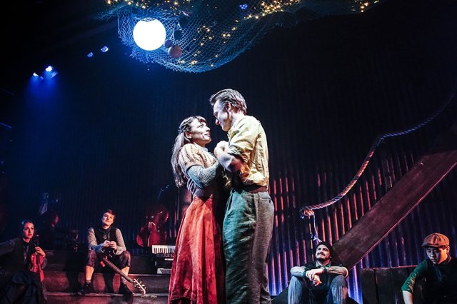Molly Osborne and Jamie Parker in The Curious Case of Benjamin Button, dancing on stage and surrounded by ensemble members