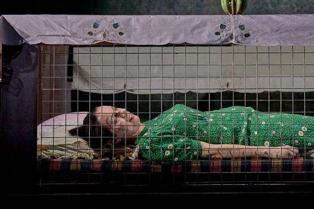 Kate O'Flynn in all of us, lying on her back in a cage