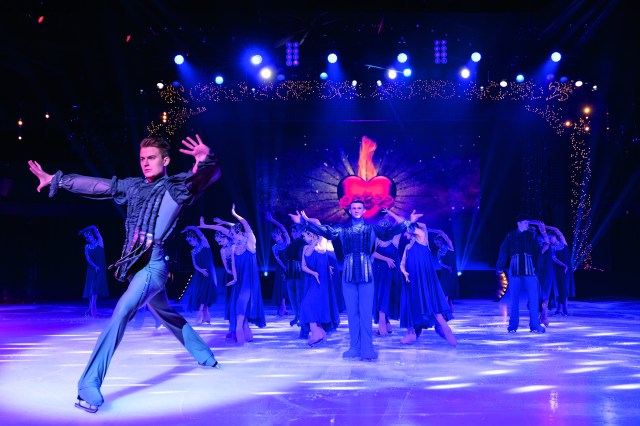 Hot Ice Show Ice skaters in elaborate, dark costumes pose on the rink in Blackpool