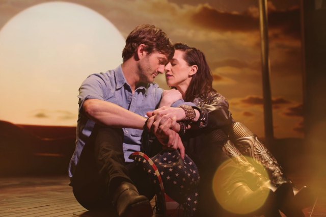 A man and woman embrace in front of a sunset in the new musical In Dreams