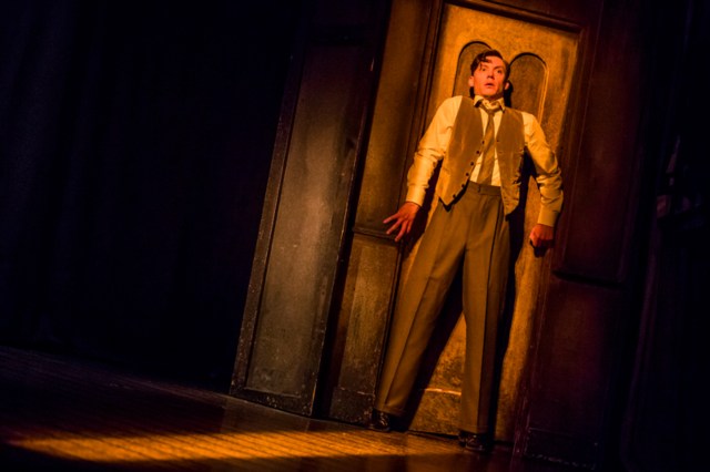 Mark Hawkins standing in front of a door in The Woman in Black