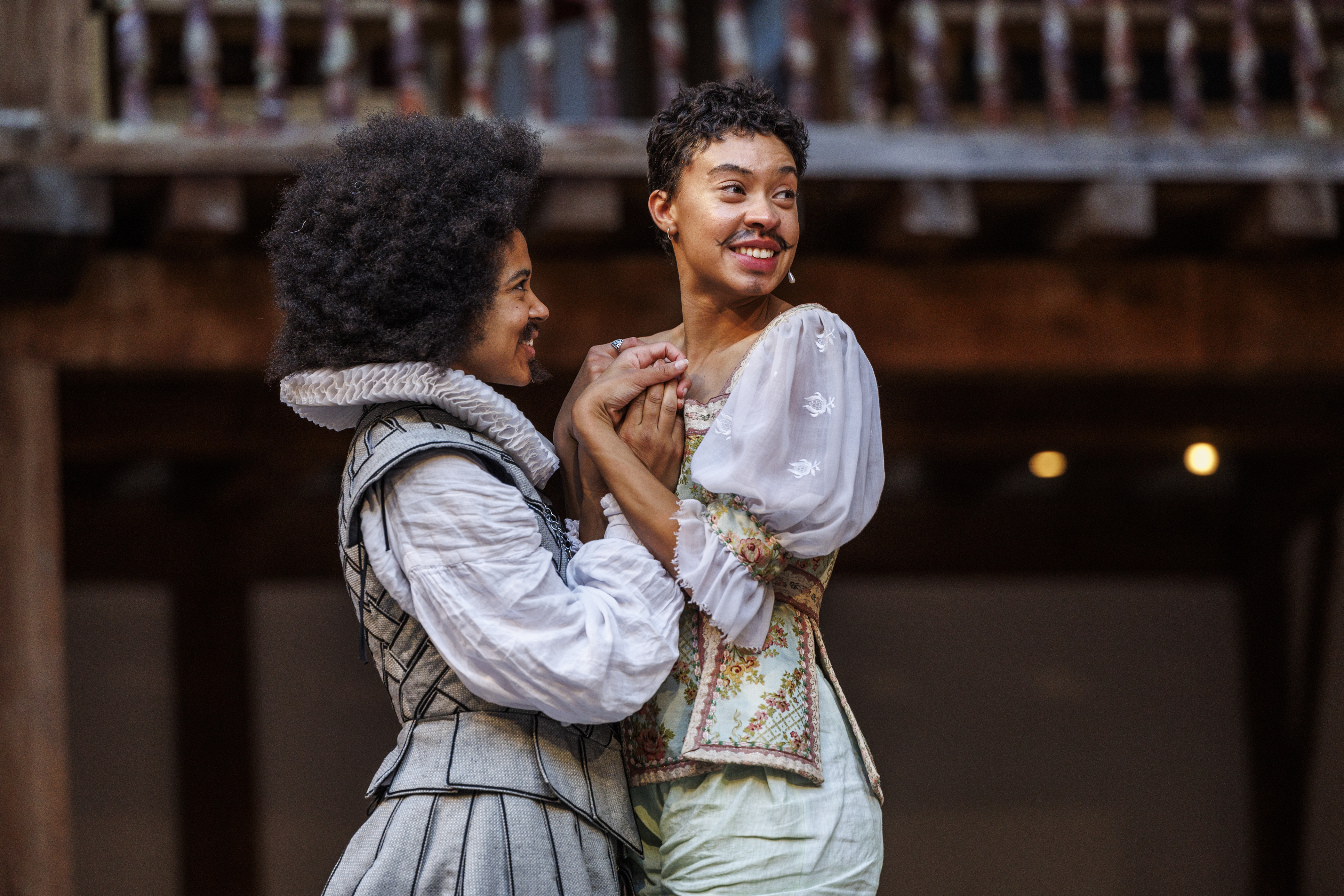 Actors Isabel Adomakoh Young and Nina Bowers embrace, as Orlando and Rosalind, in a scene from As You Like It at Shakespeare's Globe