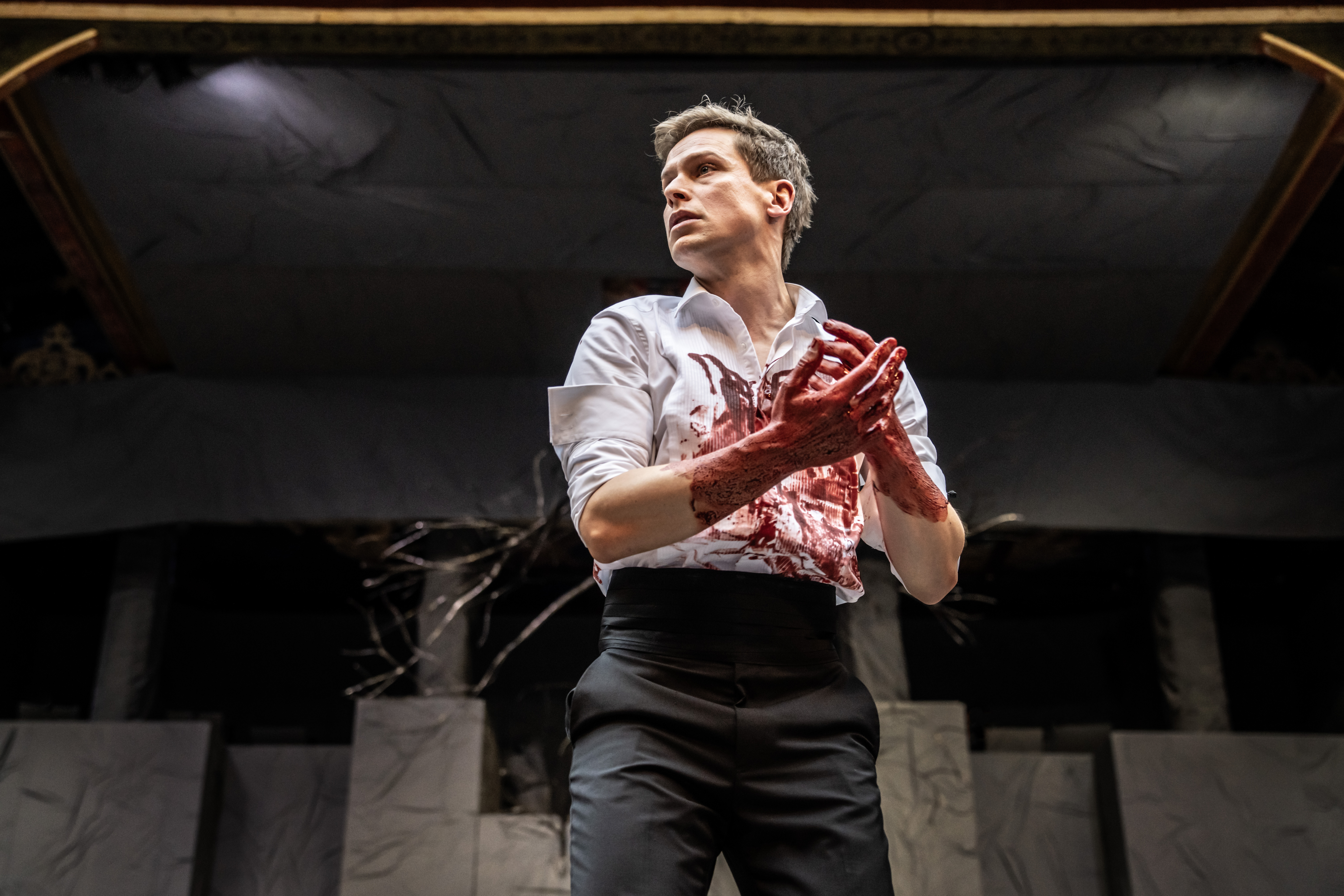 Max Bennett portrays Macbeth with blood-stained hands at Shakespeare's Globe