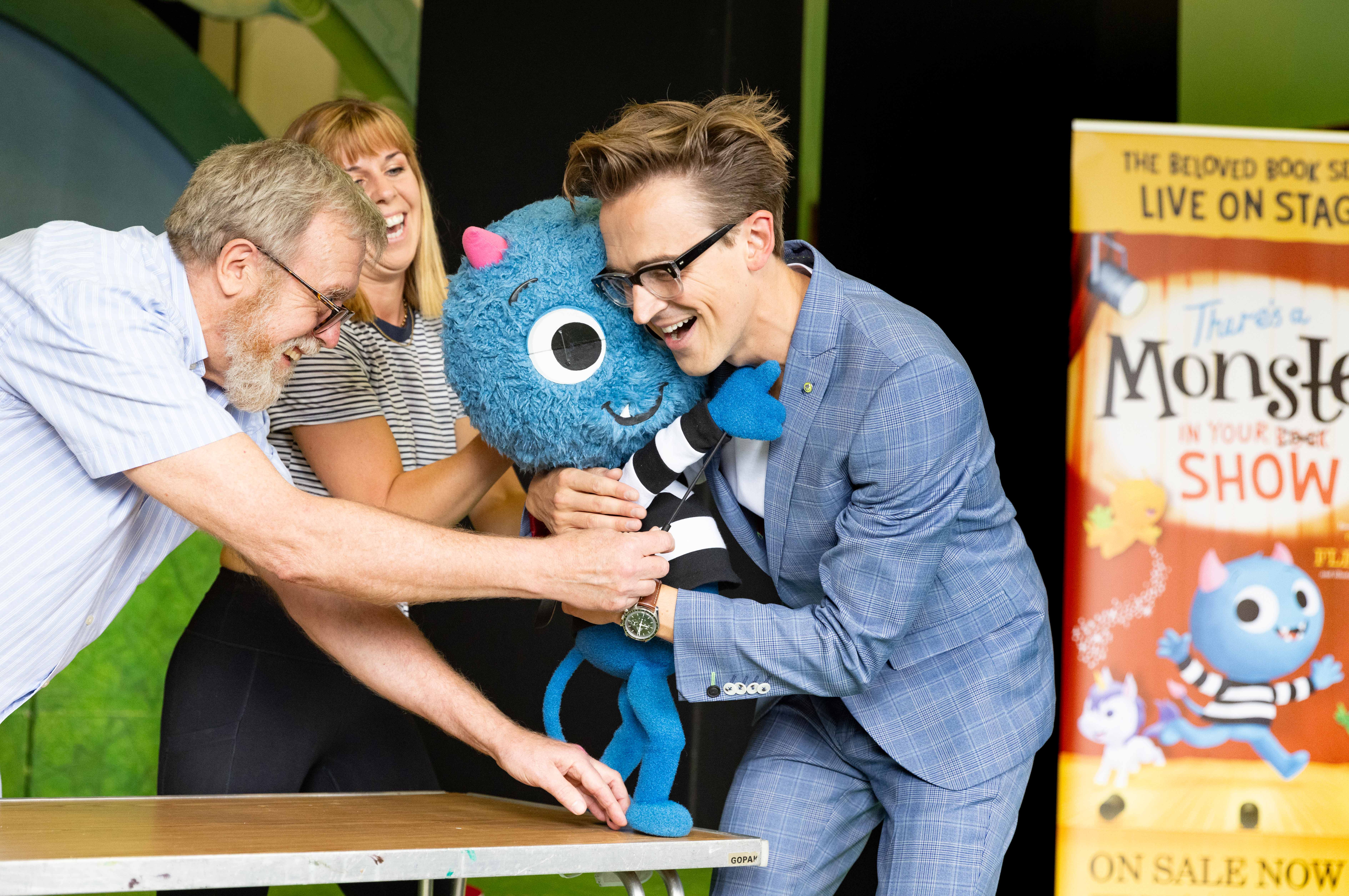 Tom Fletcher embraces a puppet from There's a Monster in Your Show
