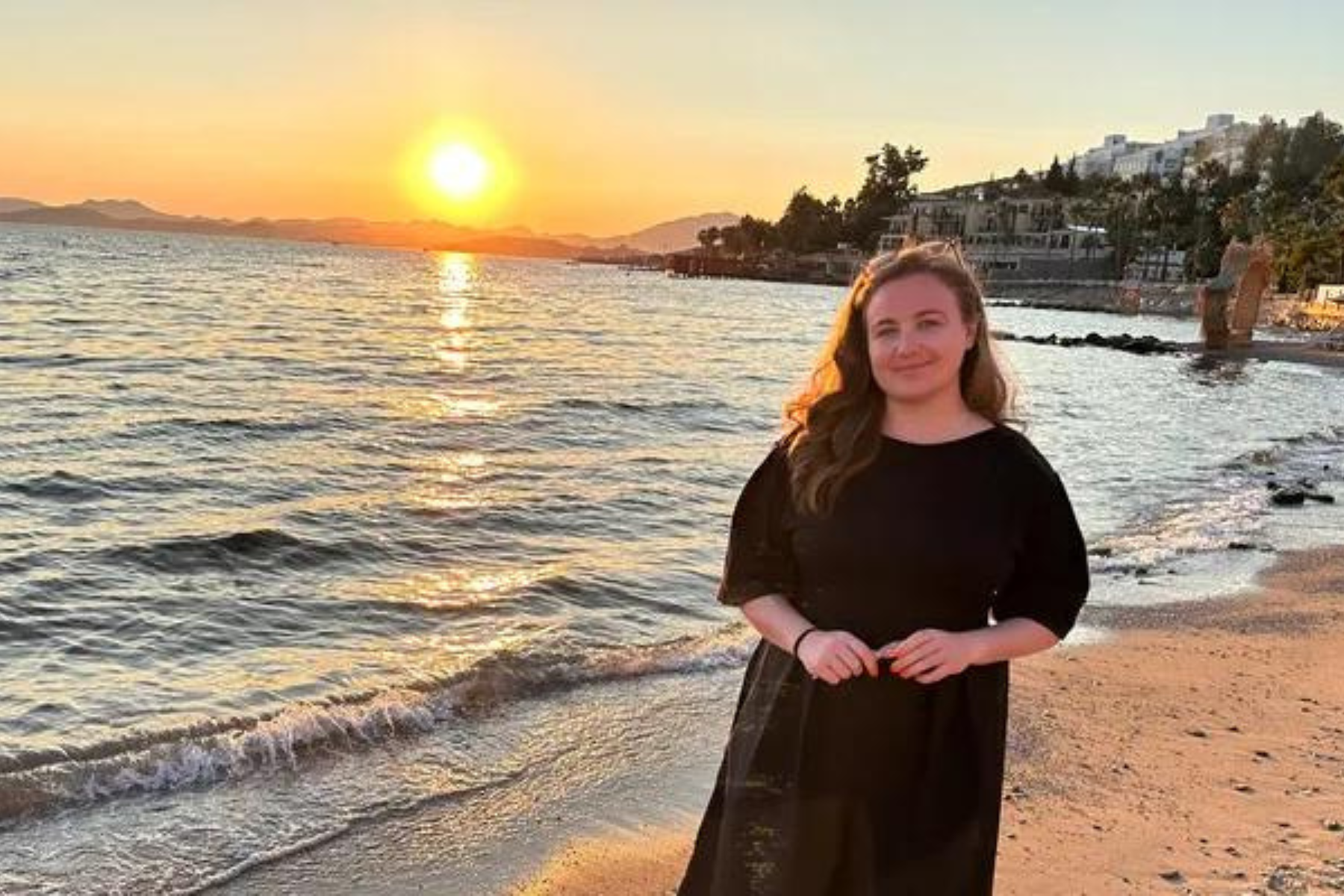 Cheryl Firth next to the sea at sunset, image via GoFundMe