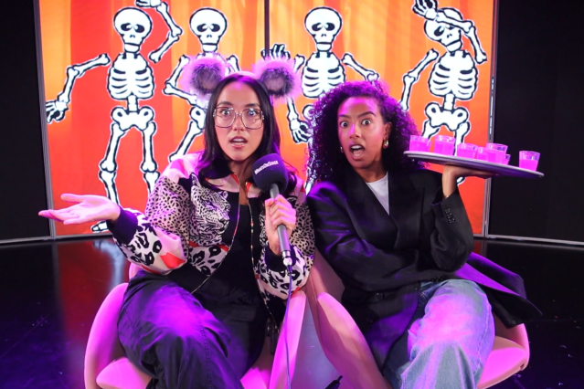 Mean Girls Halloween Grace Mouat and Elèna Gyasi hold shot glasses on stage at Mean Girls