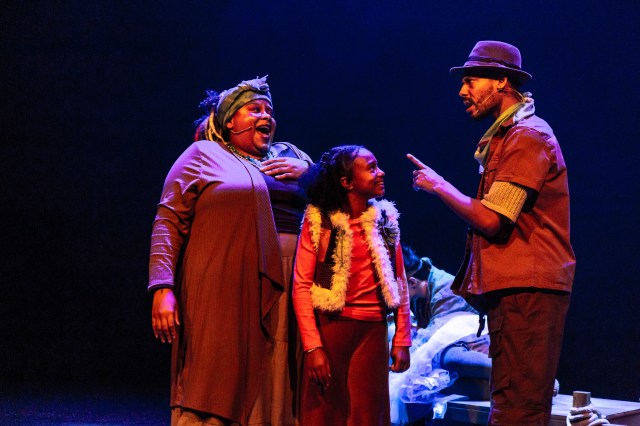 Three performers on stage
