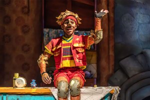A young actor dressed as Pinocchio in a pantomime production