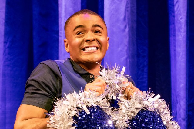 An actor on stage holding a cushion shaped like the blue diamond heart from Titanic