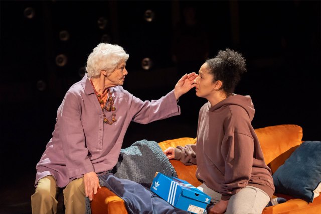 An older actress touch the cheek of a younger actress on stage