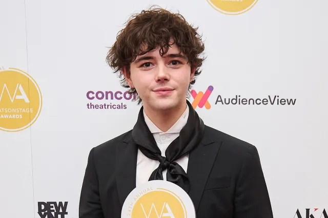 Actor Jack Wolfe holding a WhatsOnStage Award trophy