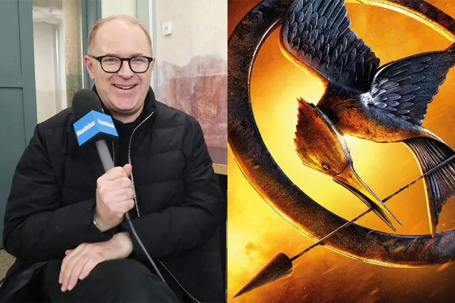 Playwright Conor McPherson holding a WhatsOnStage-branded microphone and the logo for The Hunger Games, depicting a metal symbol of a mockingjay holding an arrow in its beak