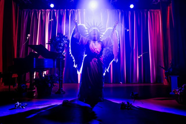 An actress dressed as an angel in a concert setting on stage