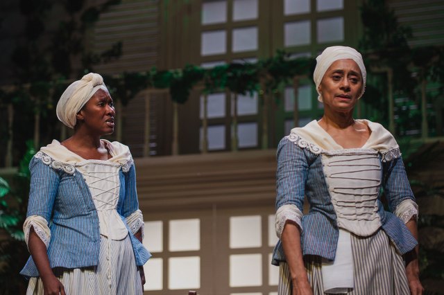 Two actresses on stage dressed as maids