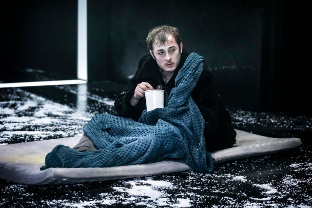 An actor on stage, portraying a man living in squalor