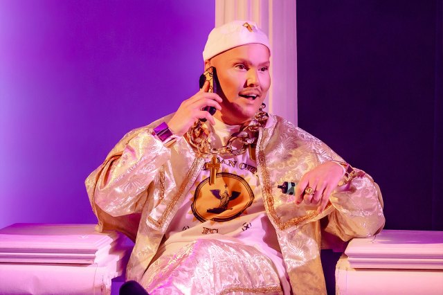 An actor on stage dressed as a golden Pope/Hip Hop character