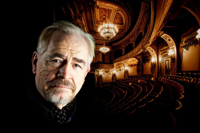 Actor Brian Cox with a theatre auditorium in the background