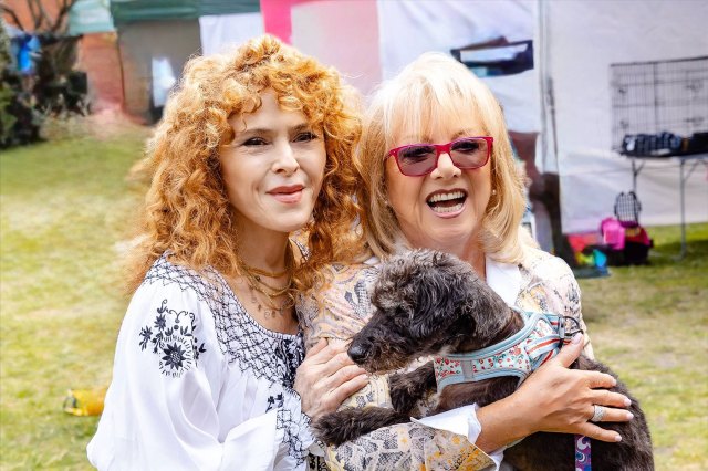 Performers Bernadette Peters and Elaine Paige, holding a dog.