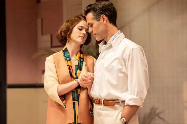 An actress and an actor share a tender moment on stage