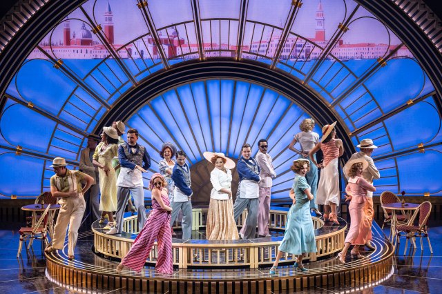 A group of actors gathered on stage during a scene of Top Hat