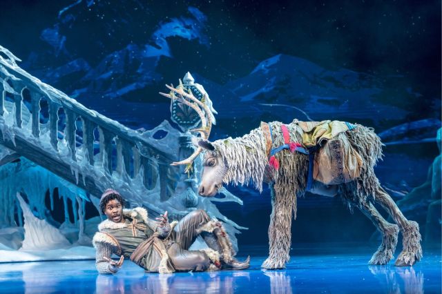 Jammy Kasongo as Kristoff lays down next to a giant reindeer