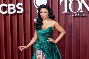 Woman in an emerald green, strapless gown posing on a red-carpet backdrop with CBS and Tony Awards signage.