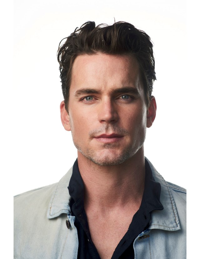 Close-up of a man with blue eyes and dark hair, wearing a light denim jacket and a dark shirt, neutral background.